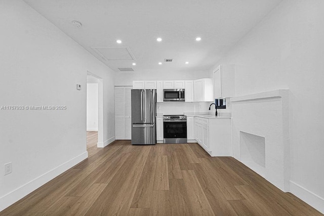 kitchen with visible vents, appliances with stainless steel finishes, dark wood-type flooring, and a sink