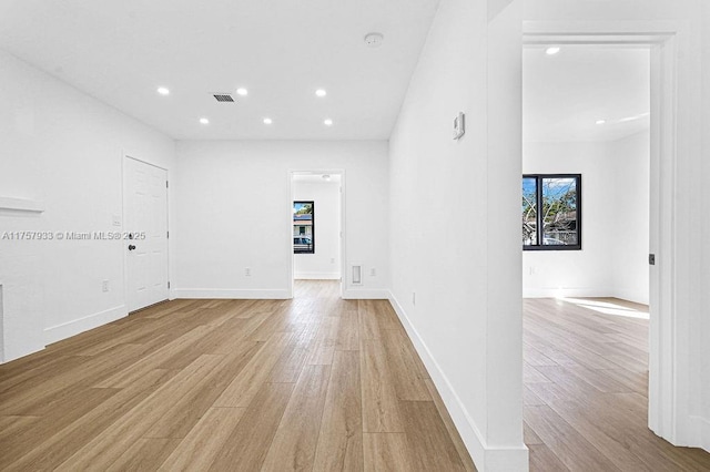 empty room with light wood finished floors, visible vents, recessed lighting, and baseboards