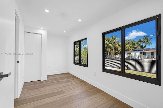 empty room with recessed lighting, baseboards, and light wood finished floors