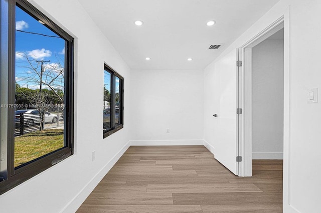 hall with recessed lighting, visible vents, baseboards, and wood finished floors