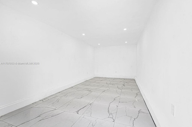 empty room with recessed lighting, marble finish floor, and baseboards