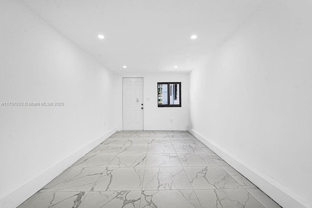 empty room featuring recessed lighting, baseboards, and marble finish floor