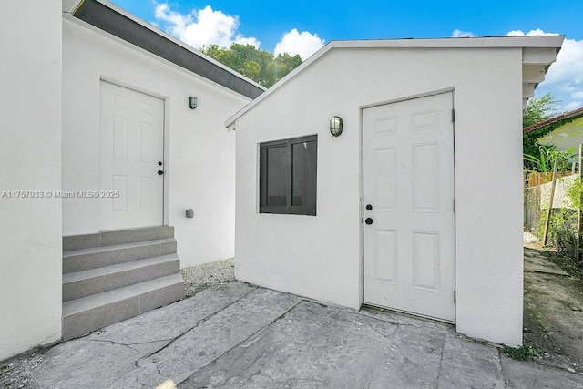 property entrance with stucco siding