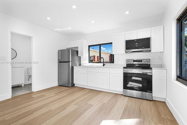 kitchen with light countertops, recessed lighting, stainless steel appliances, light wood-style floors, and white cabinetry