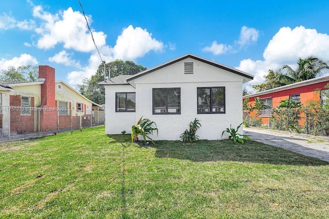 exterior space featuring a front yard, fence, and stucco siding