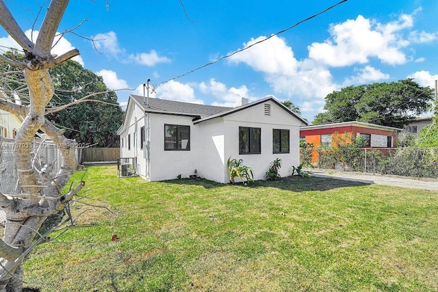 exterior space featuring stucco siding, a fenced backyard, and a front lawn