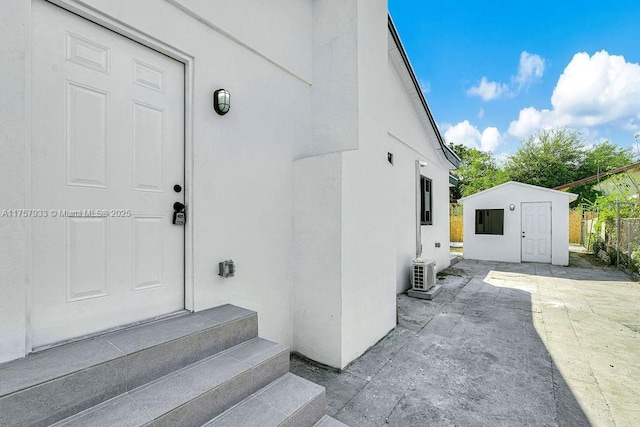 doorway to property featuring a patio area, stucco siding, and ac unit