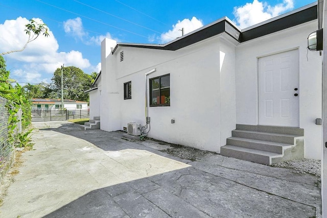 exterior space with a patio, cooling unit, fence, stucco siding, and entry steps