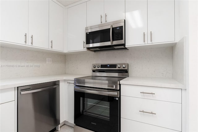 232 NW 58th Ct, Miami, FL 33126 - kitchen with backsplash, appliances with stainless steel finishes, and white cabinetry