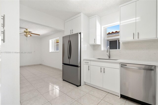 232 NW 58th Ct, Miami, FL 33126 - kitchen featuring a textured ceiling, light countertops, appliances with stainless steel finishes, and a sink