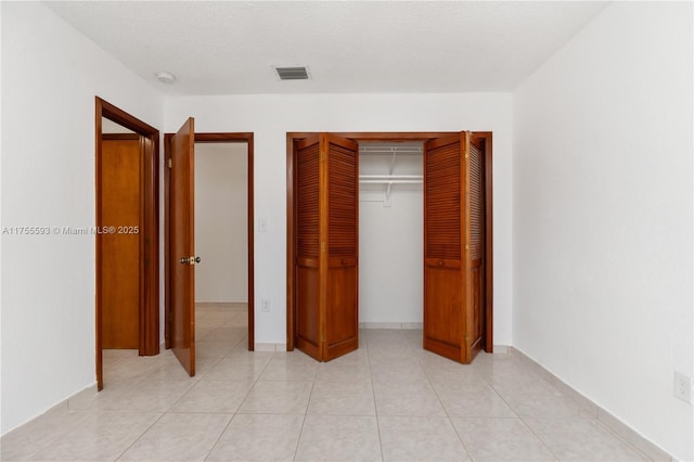 232 NW 58th Ct, Miami, FL 33126 - unfurnished bedroom featuring light tile patterned floors and a textured ceiling