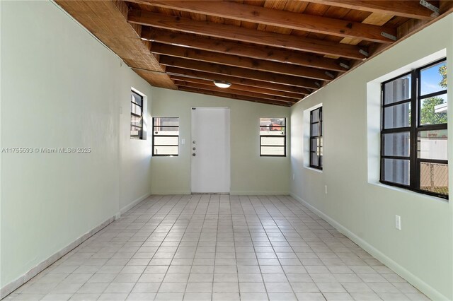232 NW 58th Ct, Miami, FL 33126 - unfurnished room featuring light tile patterned floors, wood ceiling, lofted ceiling with beams, and baseboards