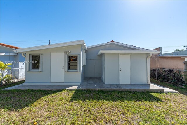 232 NW 58th Ct, Miami, FL 33126 - rear view of property featuring a yard, fence, and stucco siding