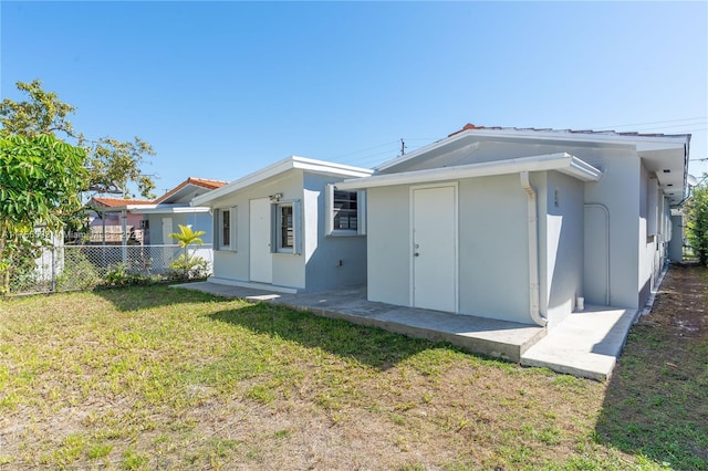 232 NW 58th Ct, Miami, FL 33126 - rear view of property featuring stucco siding, a lawn, and fence