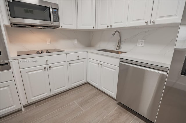 kitchen featuring a sink, appliances with stainless steel finishes, and white cabinets