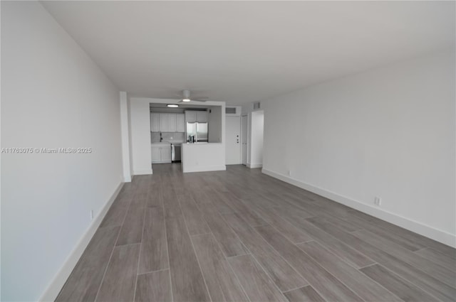 unfurnished living room with visible vents, baseboards, and wood finished floors