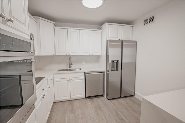 kitchen with visible vents, white cabinets, appliances with stainless steel finishes, and a sink