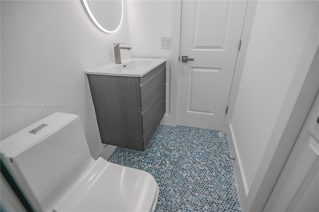 bathroom featuring tile patterned floors, baseboards, toilet, and vanity