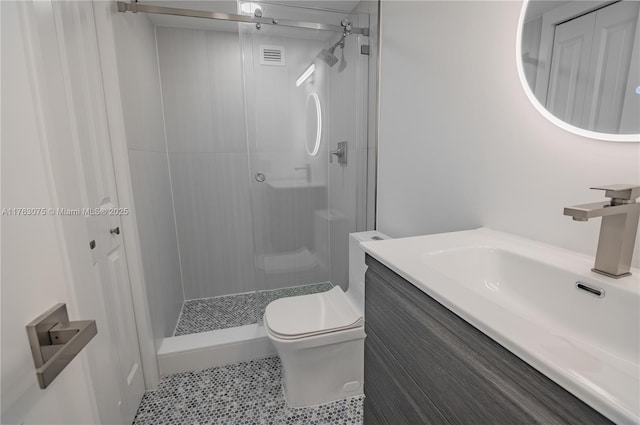 bathroom featuring vanity, a shower stall, toilet, and visible vents