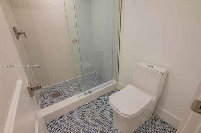 full bath with tile patterned flooring, a stall shower, toilet, and baseboards