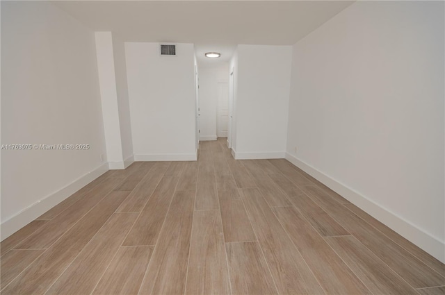 unfurnished room with visible vents, baseboards, and wood tiled floor