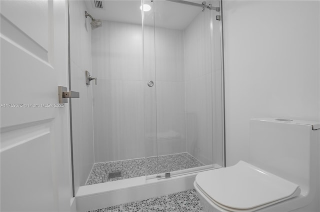 bathroom with toilet, visible vents, and a stall shower