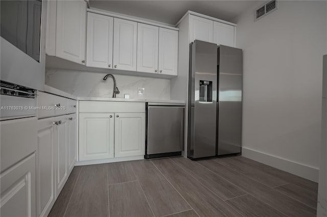 kitchen featuring a sink, white cabinetry, appliances with stainless steel finishes, and light countertops