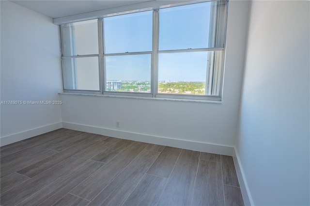 spare room featuring wood finished floors and baseboards