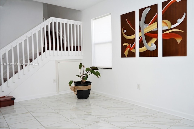 stairs featuring baseboards and marble finish floor