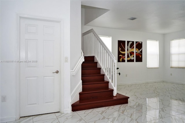 stairway featuring visible vents, marble finish floor, and baseboards