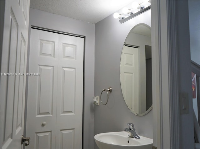 bathroom with a sink and a textured ceiling