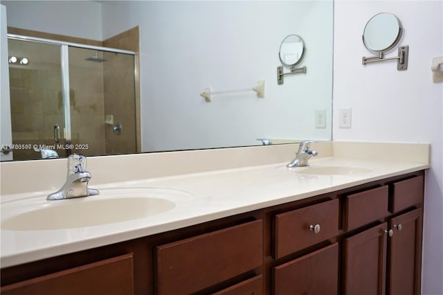 bathroom featuring double vanity, a stall shower, and a sink