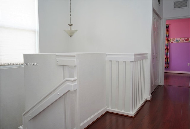 hallway featuring an upstairs landing, visible vents, baseboards, and dark wood-style flooring