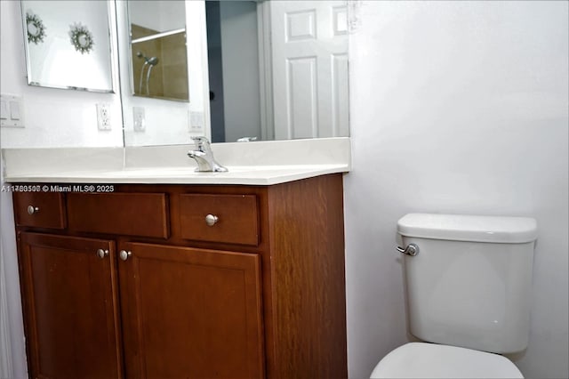 bathroom featuring toilet, walk in shower, and vanity