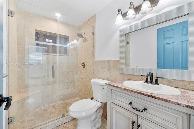 full bathroom with vanity, toilet, tile walls, and a shower stall