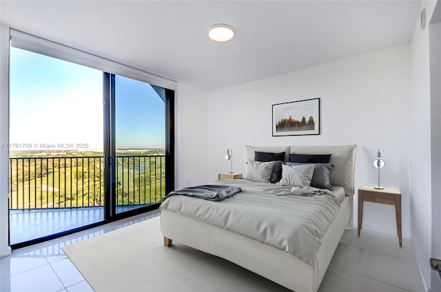 tiled bedroom featuring a wall of windows and access to outside