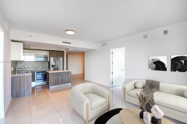 living room featuring light tile patterned floors and visible vents