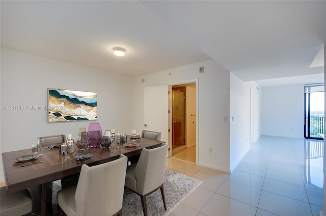 dining space featuring light tile patterned flooring and baseboards