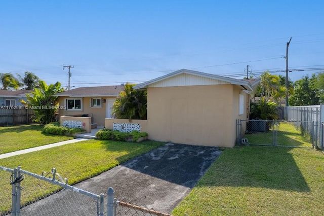 view of front of property featuring stucco siding, fence private yard, and a front lawn