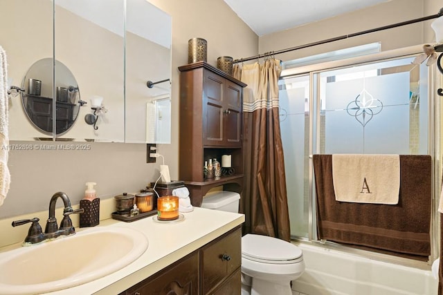 bathroom with combined bath / shower with glass door, toilet, and vanity