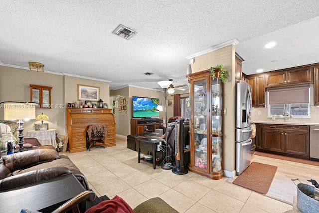 living room featuring light tile patterned floors, visible vents, a ceiling fan, and crown molding