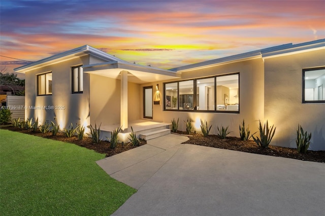 view of front facade featuring a yard and stucco siding