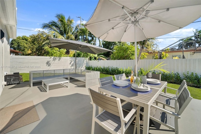 view of patio with outdoor dining area and a fenced backyard