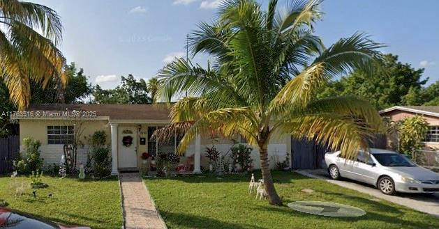 view of front facade with stucco siding, driveway, and a front lawn