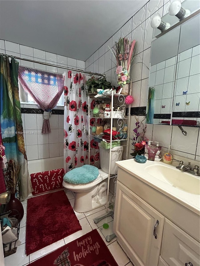 bathroom with vanity, shower / bath combo with shower curtain, tile walls, toilet, and tile patterned floors