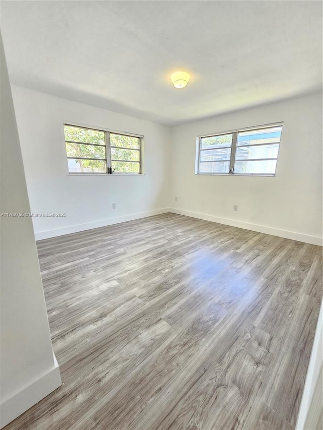 empty room with baseboards and wood finished floors