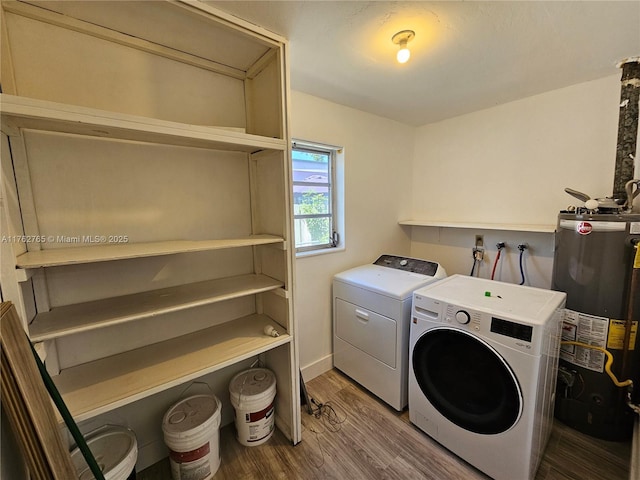 laundry area featuring gas water heater, wood finished floors, laundry area, and washer and dryer