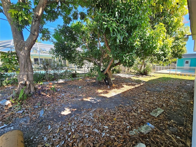 view of yard featuring glass enclosure and fence