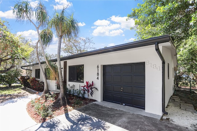 ranch-style home with stucco siding, driveway, and a garage