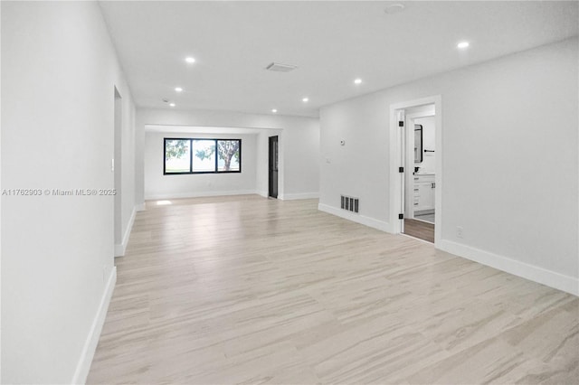 empty room featuring visible vents, recessed lighting, baseboards, and light wood-type flooring